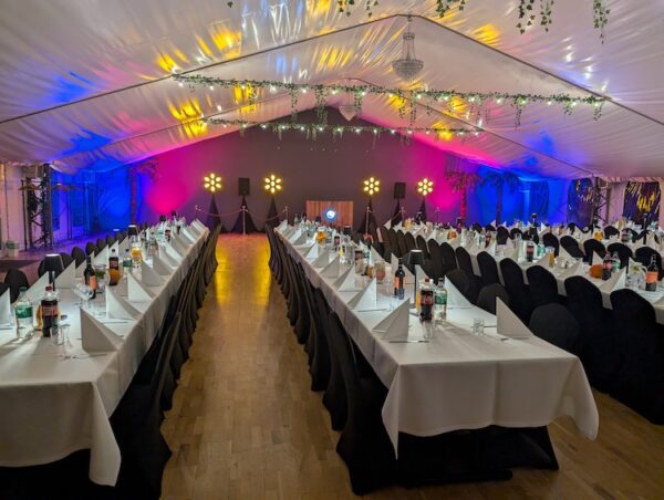 Bankiety firmowe pod Warszawą w namiocie eventowym – nowoczesna aranżacja z długimi stołami biesiadnymi na 200 osób